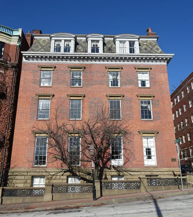 The Beacon Hill Federal bowfront (1800-1840) is Boston's most iconic urban rowhouse — a curved bay window facing a brick-paved street, with refined Federal detailing on a narrow city lot.